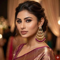 Woman wearing a traditional saree with gold and purple jewelry in a warm-toned setting