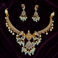 Ornate necklace and earrings set on a purple fabric background