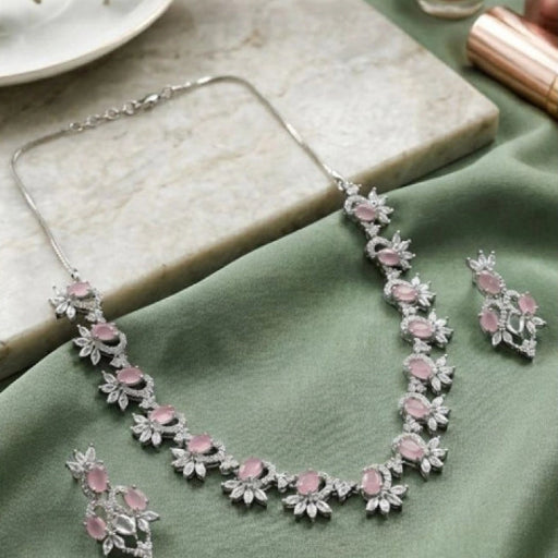 Jewelry set with pink stones on a green surface