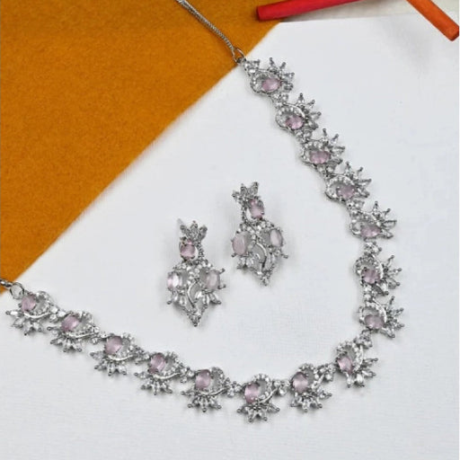 Silver jewelry set with pink stones on a white and orange background